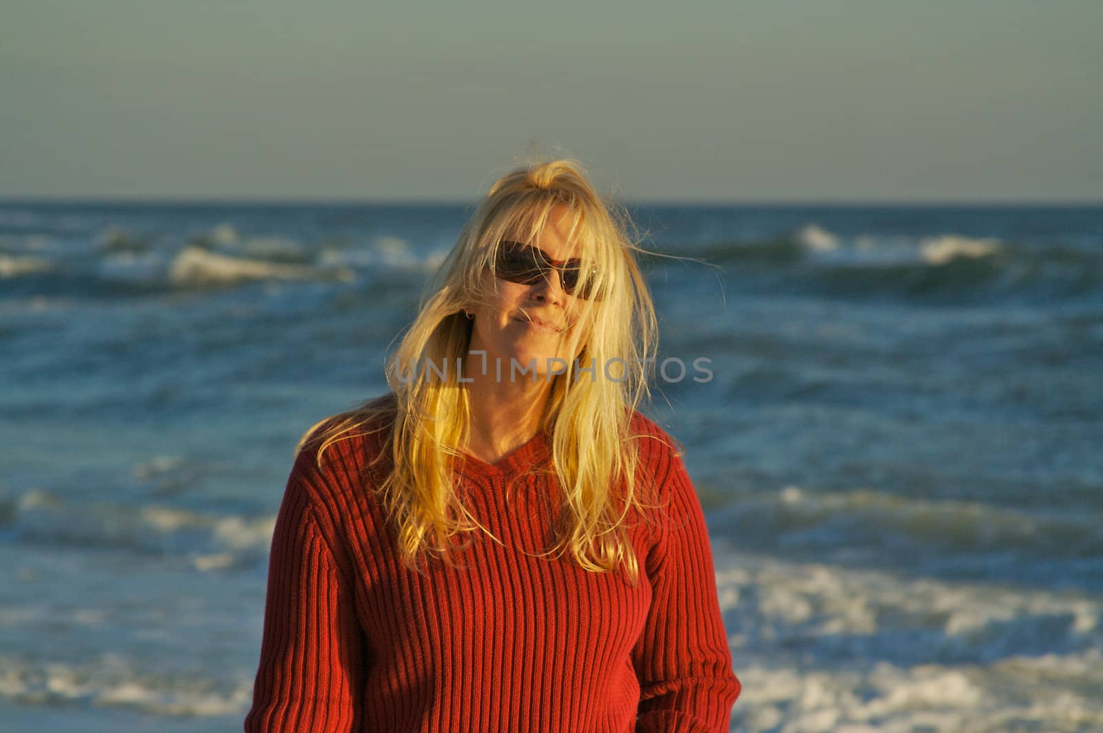 Beautiful woman on the beach at sunset. Hair wonderfully enjoying the breeze.