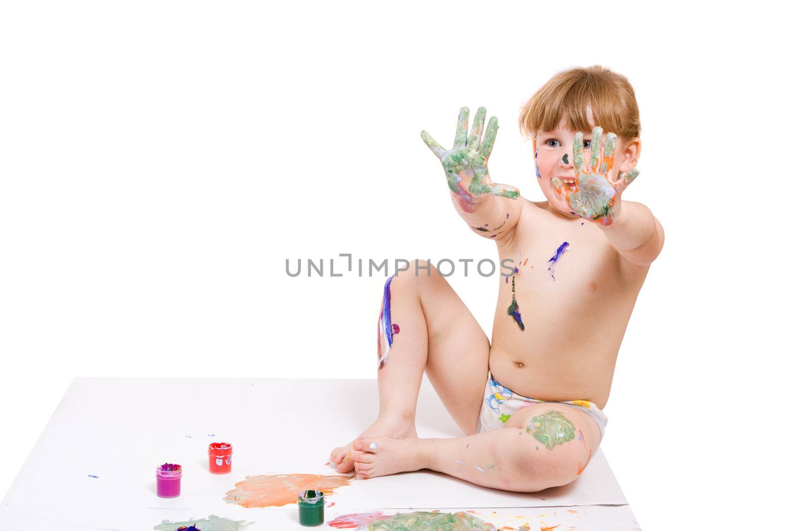 a girl with dirty face and hands of color paint seat on the floor and show her hands
