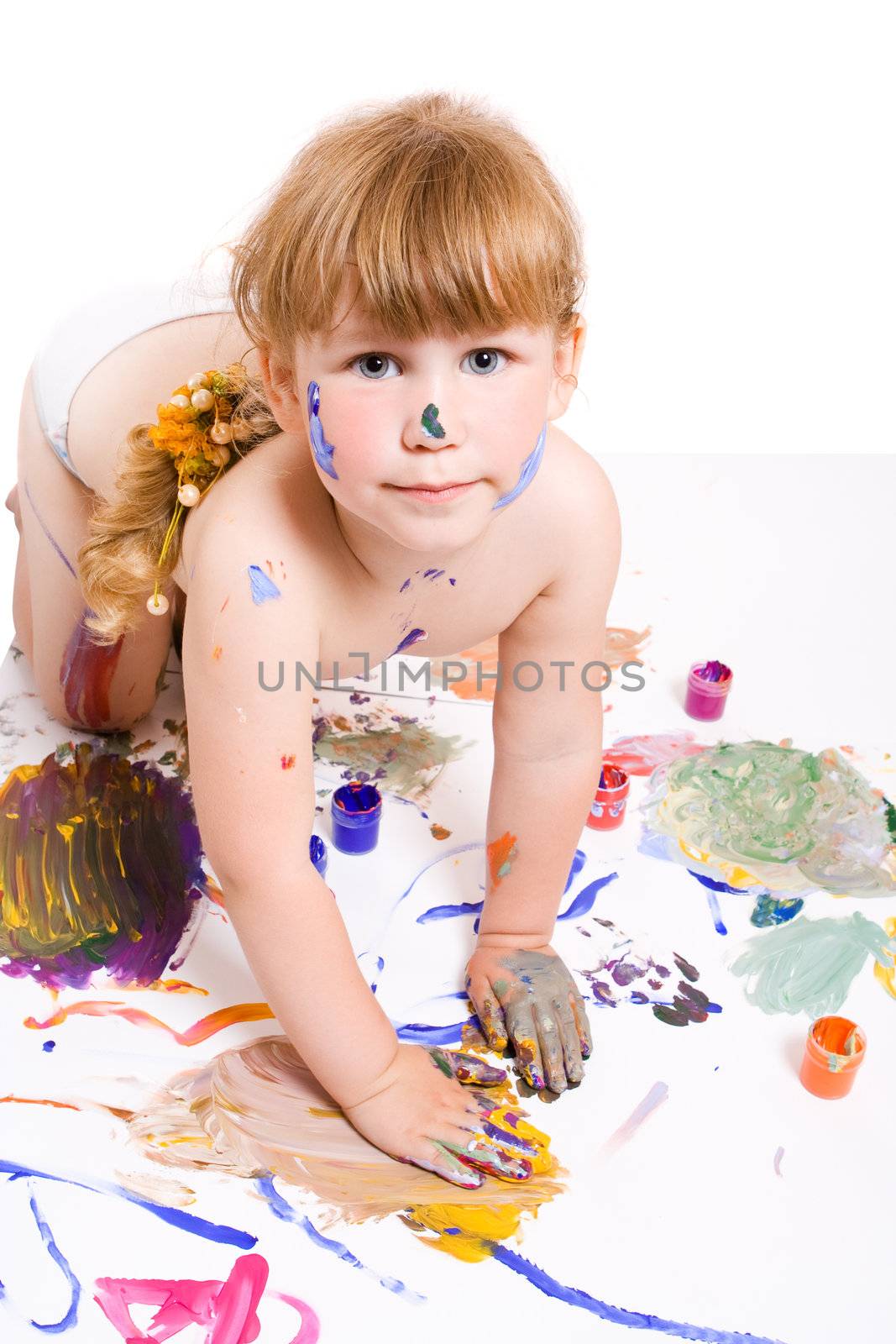 a girl with dirty face and hands of color paint seat on the dirty floor