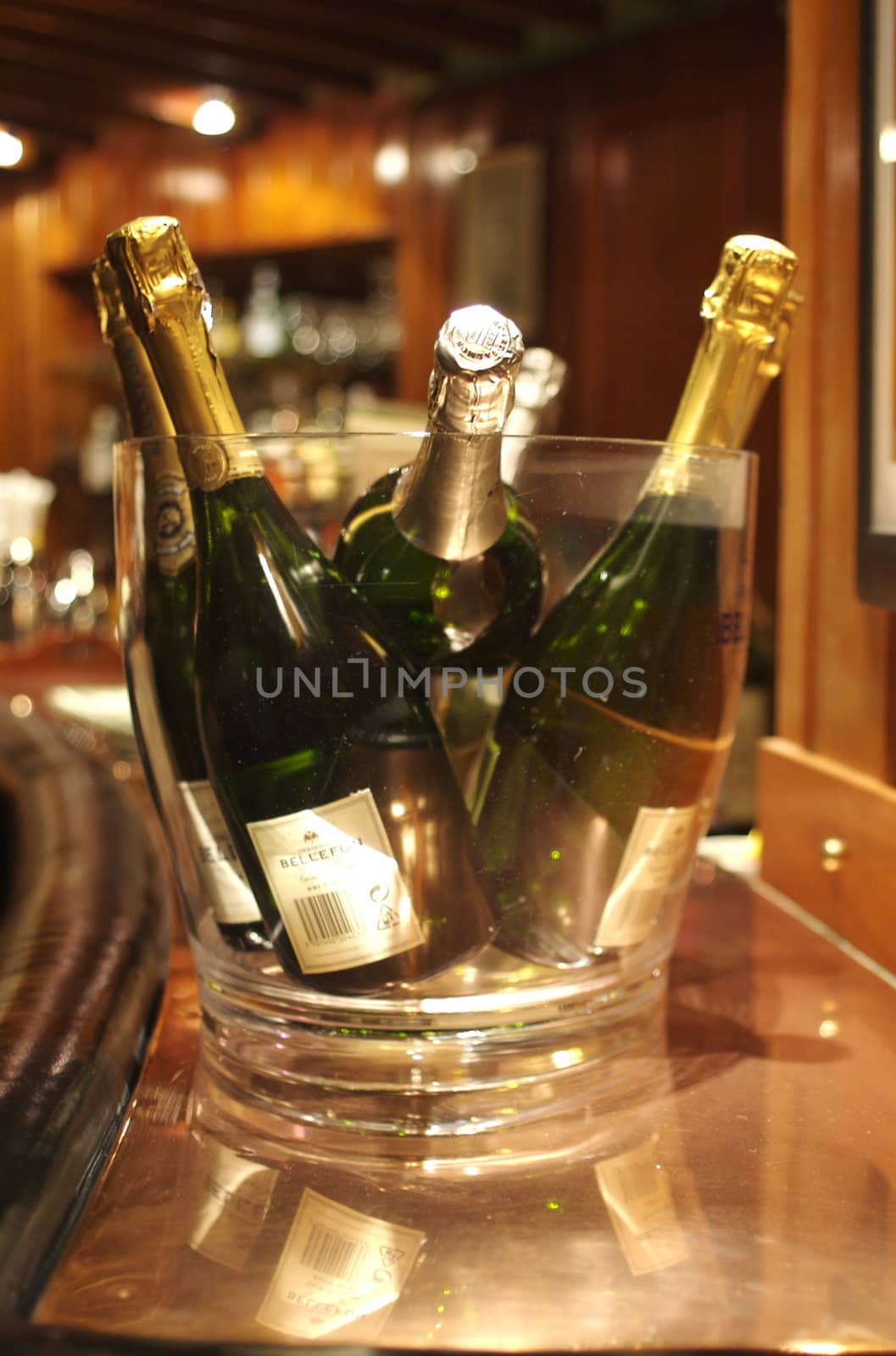 Glass bucket of champagne bottles on a bar