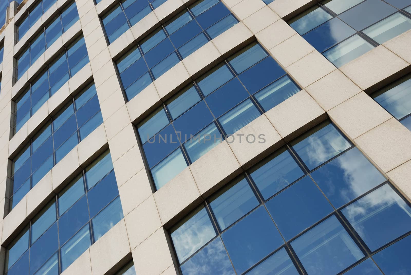 windows of a shiny skyscraper reflecting clouds