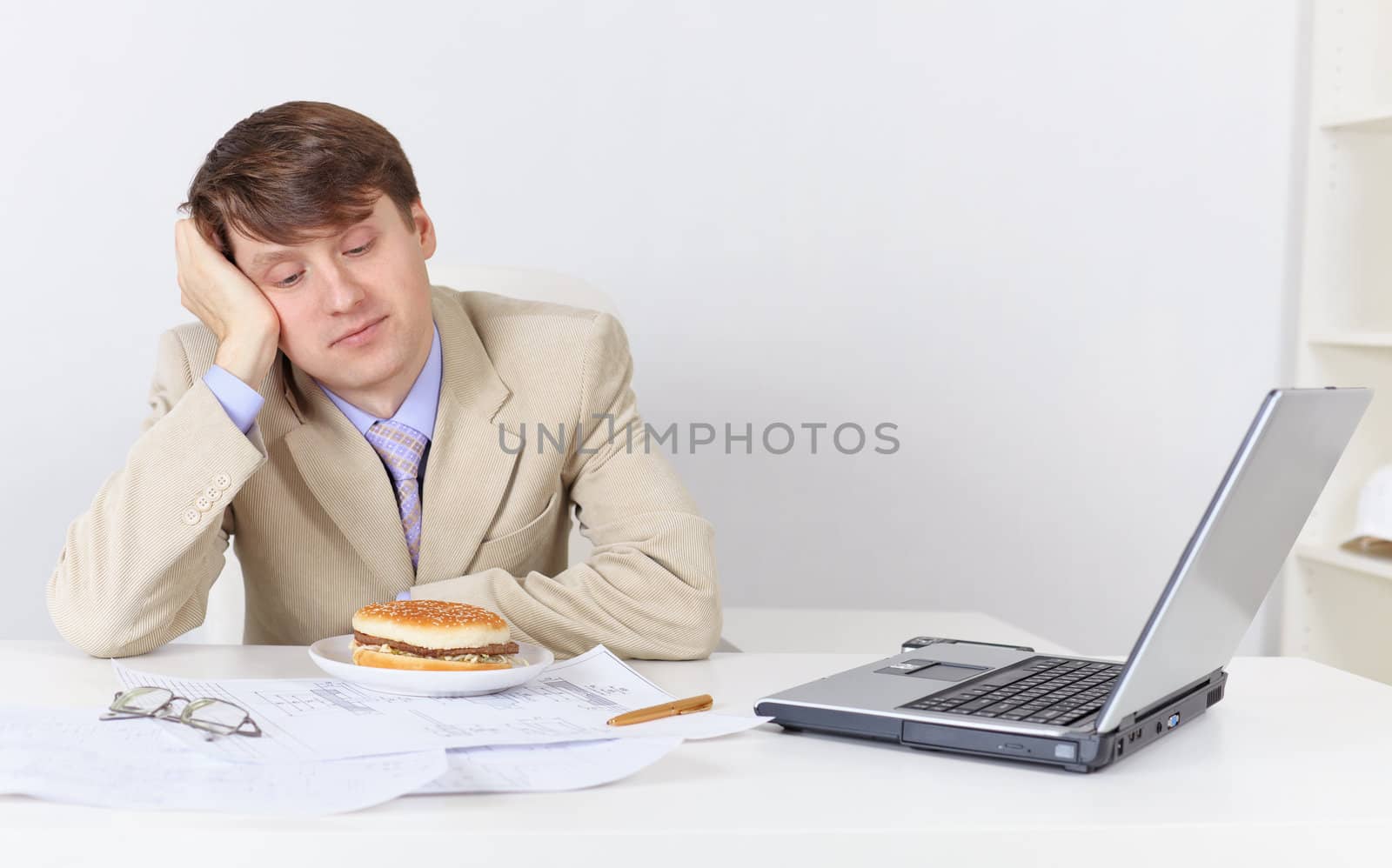 Young businessman, dreamily looking at the sandwich