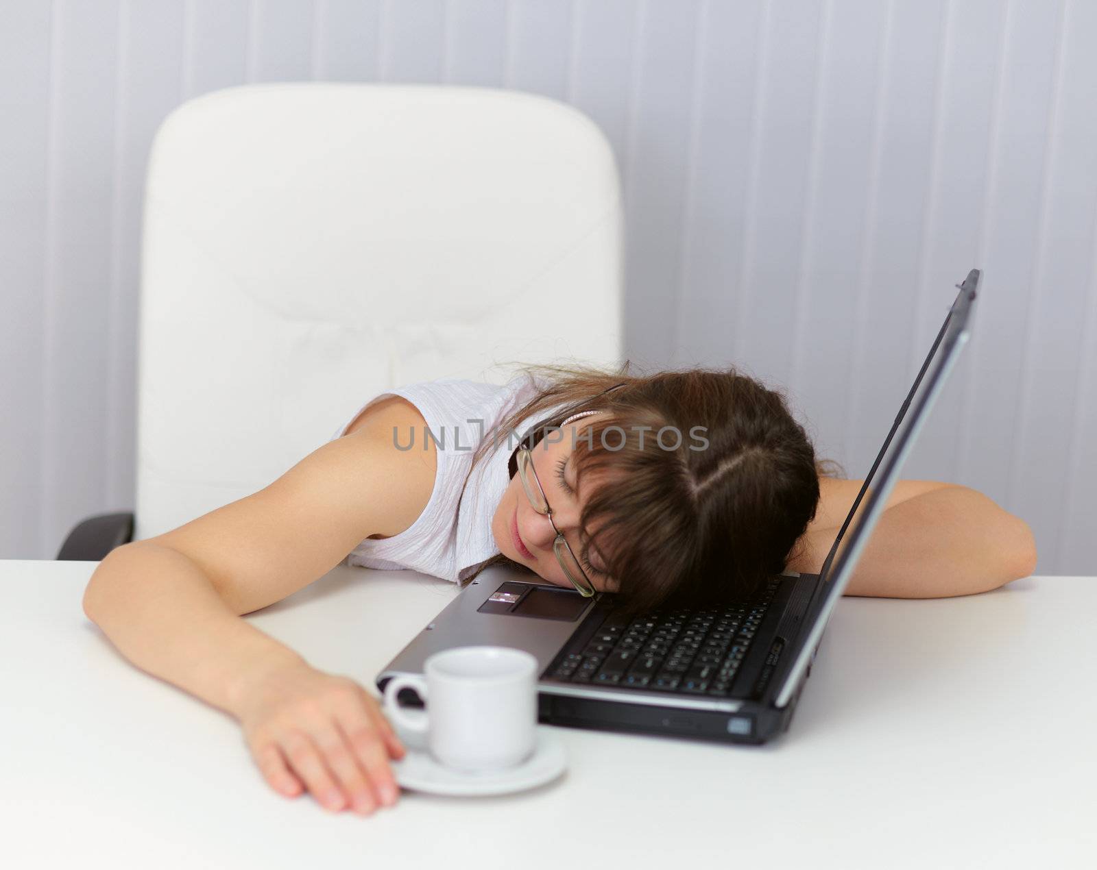 The woman was tired and sleeping on the keyboard of a laptop