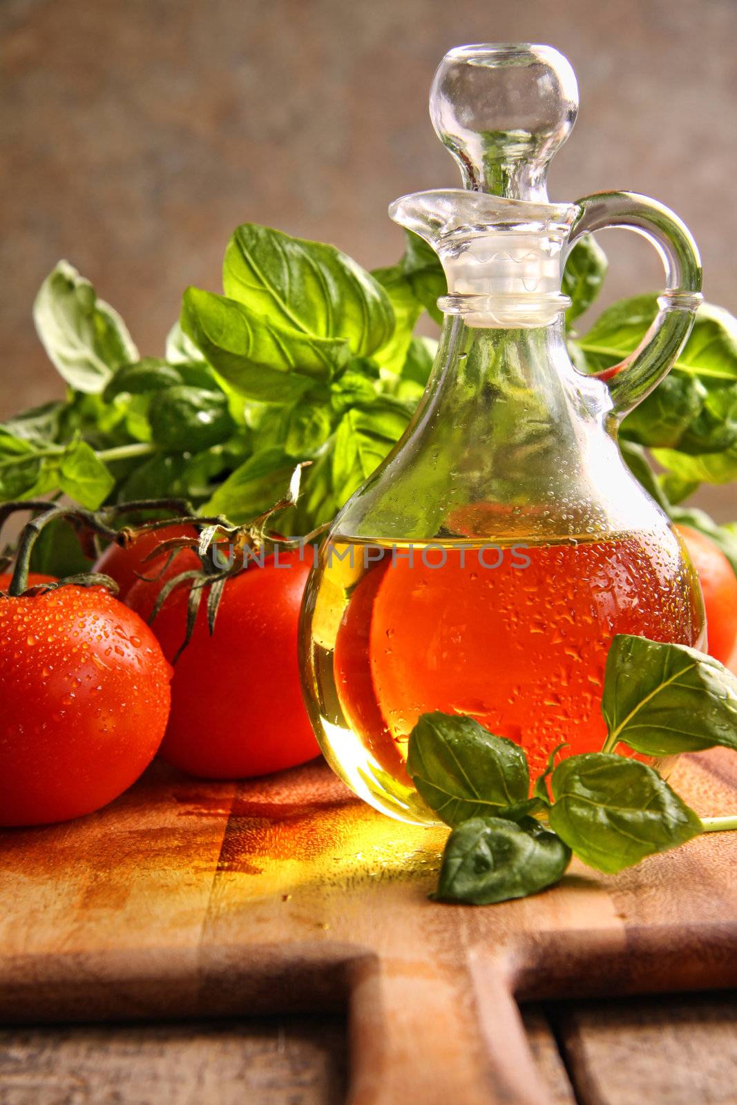 Bottle of olive oil with tomatoes and herbs