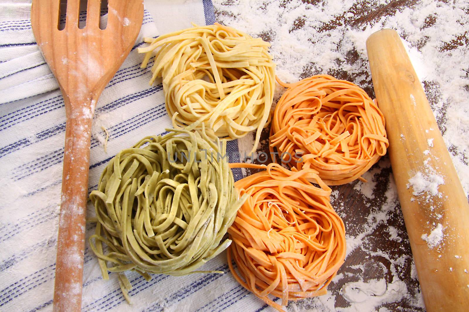 Assortment of different colored italian pasta on flour