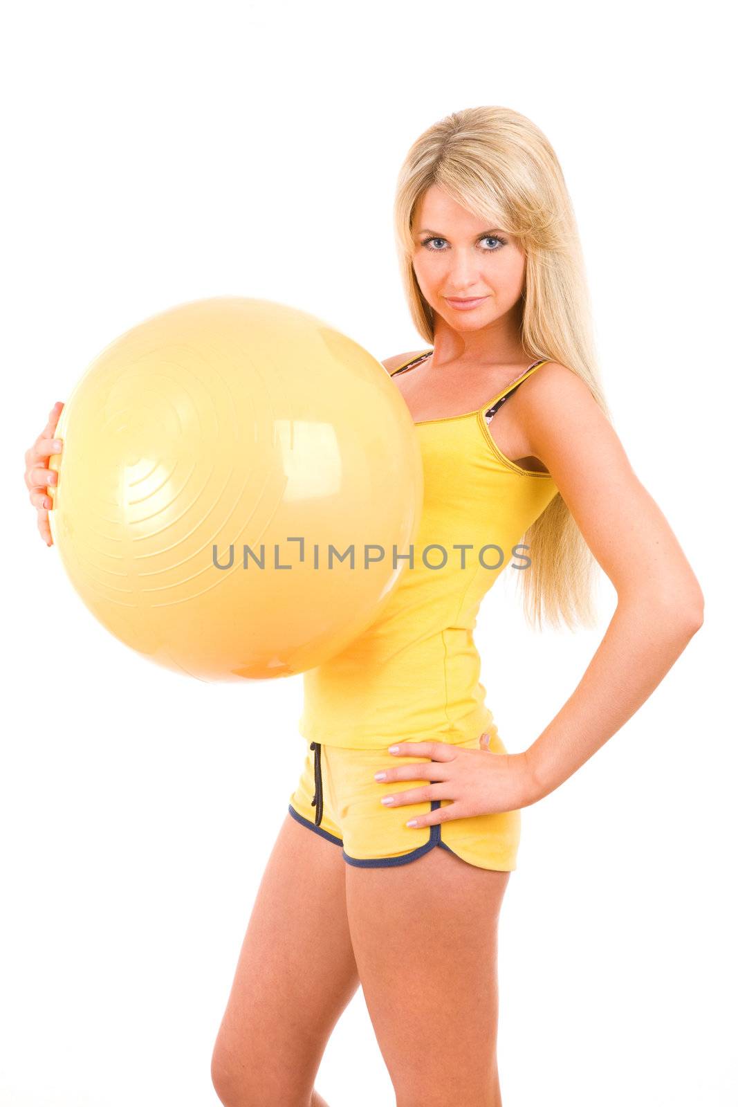 young woman with a big yellow ball in her hands goes in for fitness