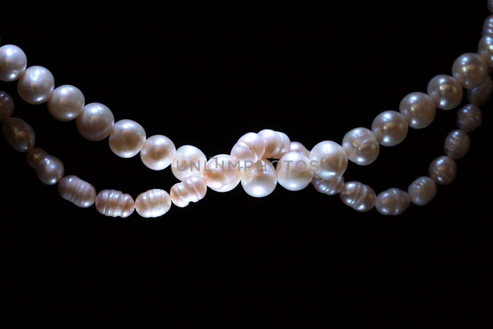 Two white pearl threads isolated on black background