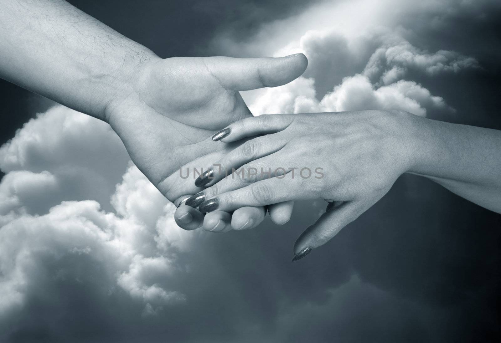 Man's and female hand on a background of the sky