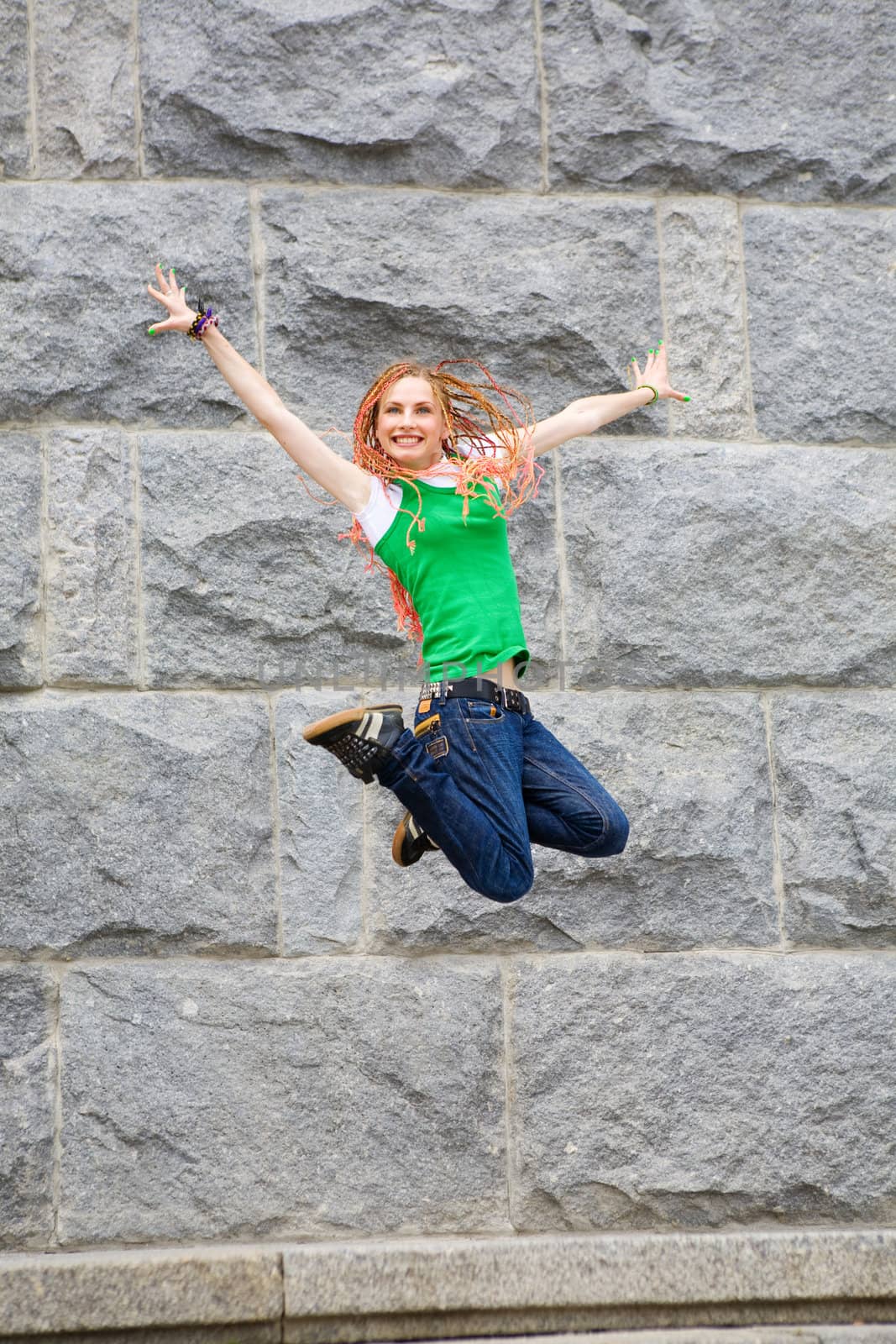 modern girl jumping near the wall