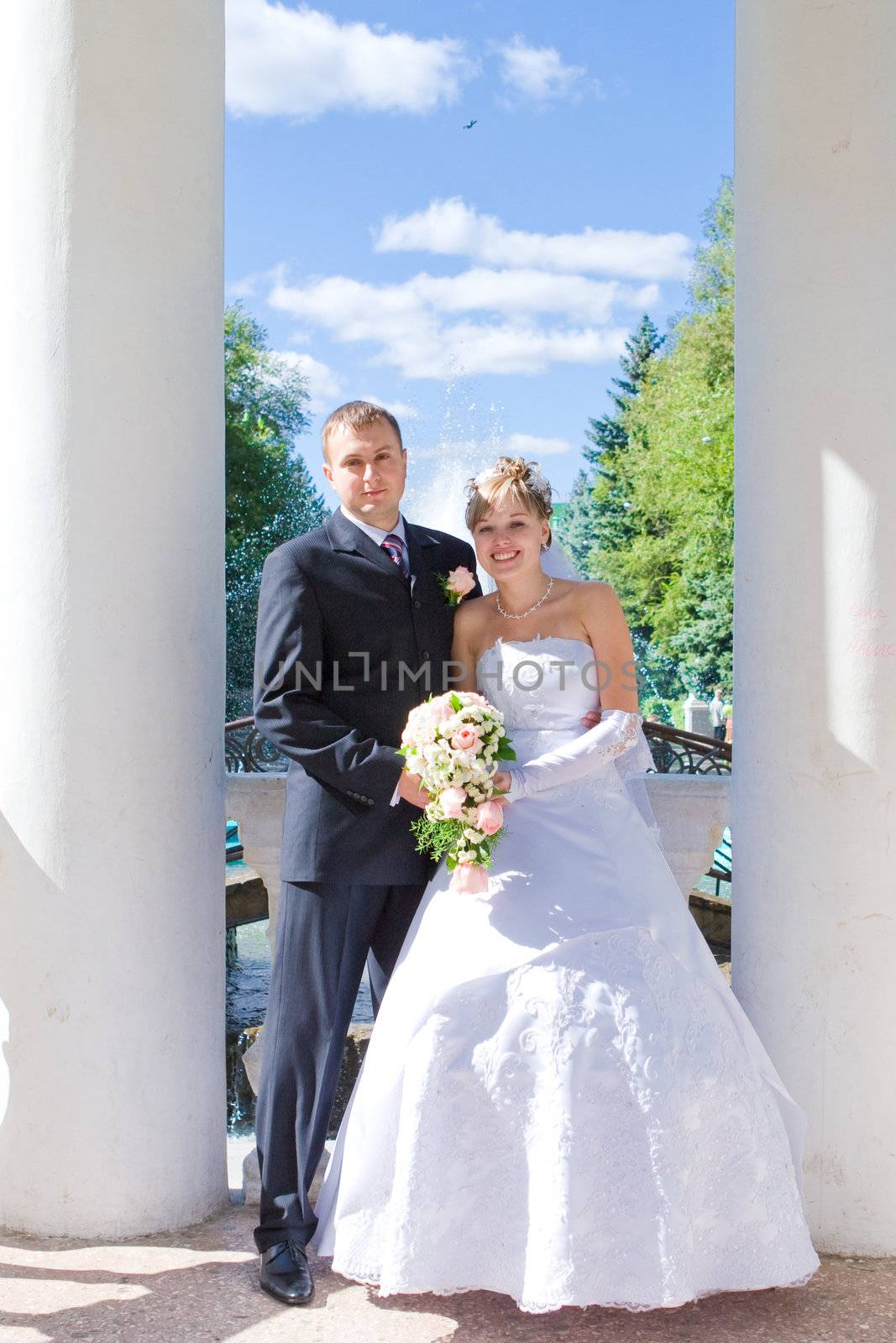 bride and groom in a opened house with columns