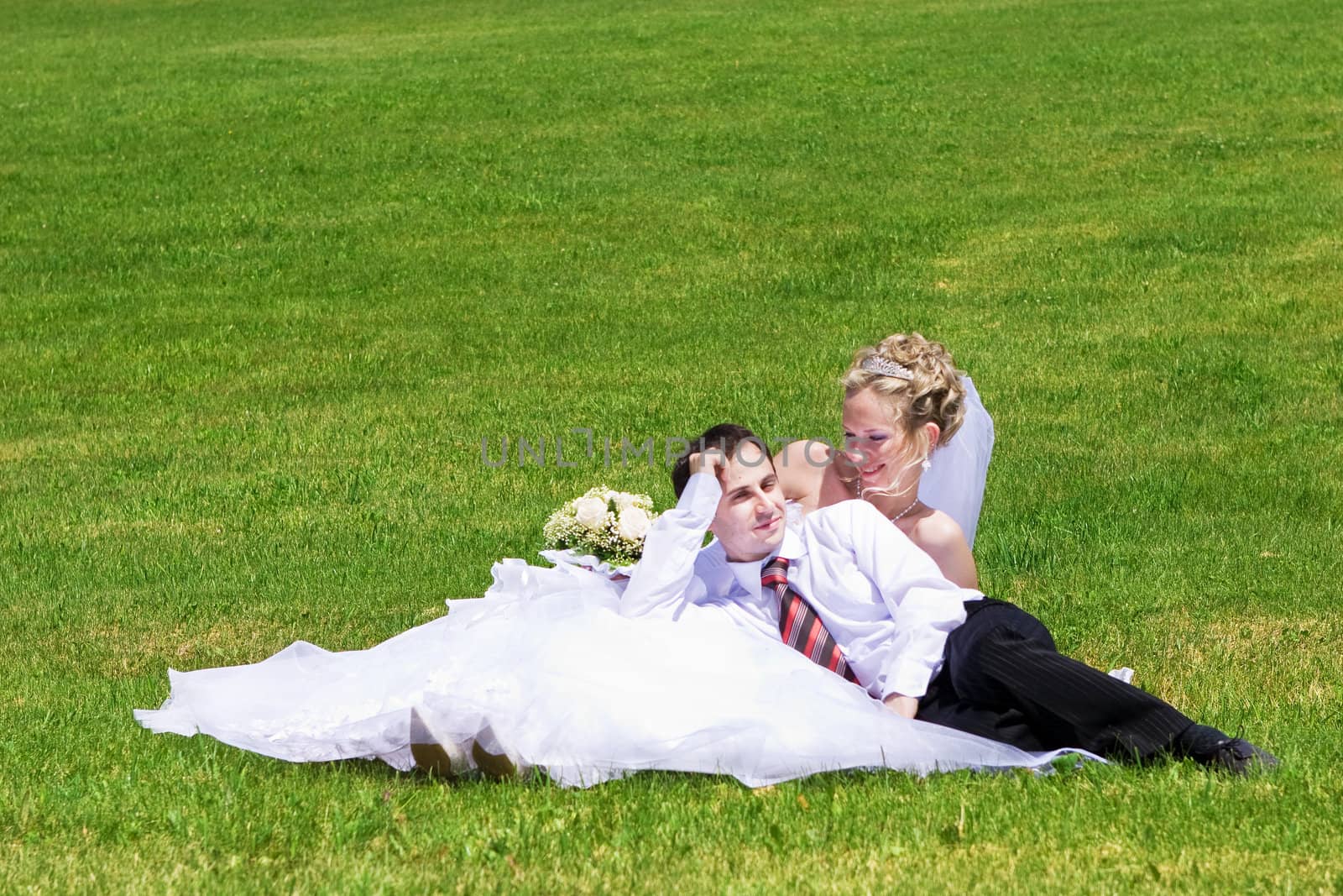 rest of newly married couple on the grass