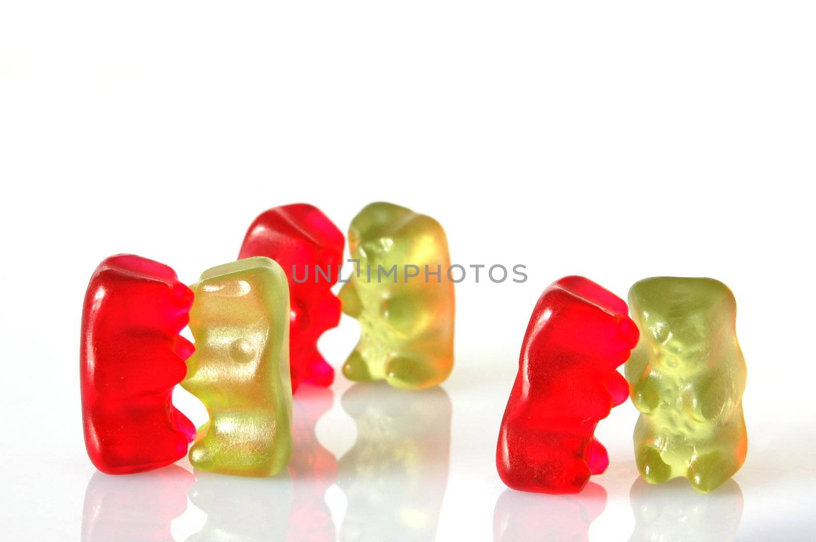 sweet gummy bears dancing on a party on white background