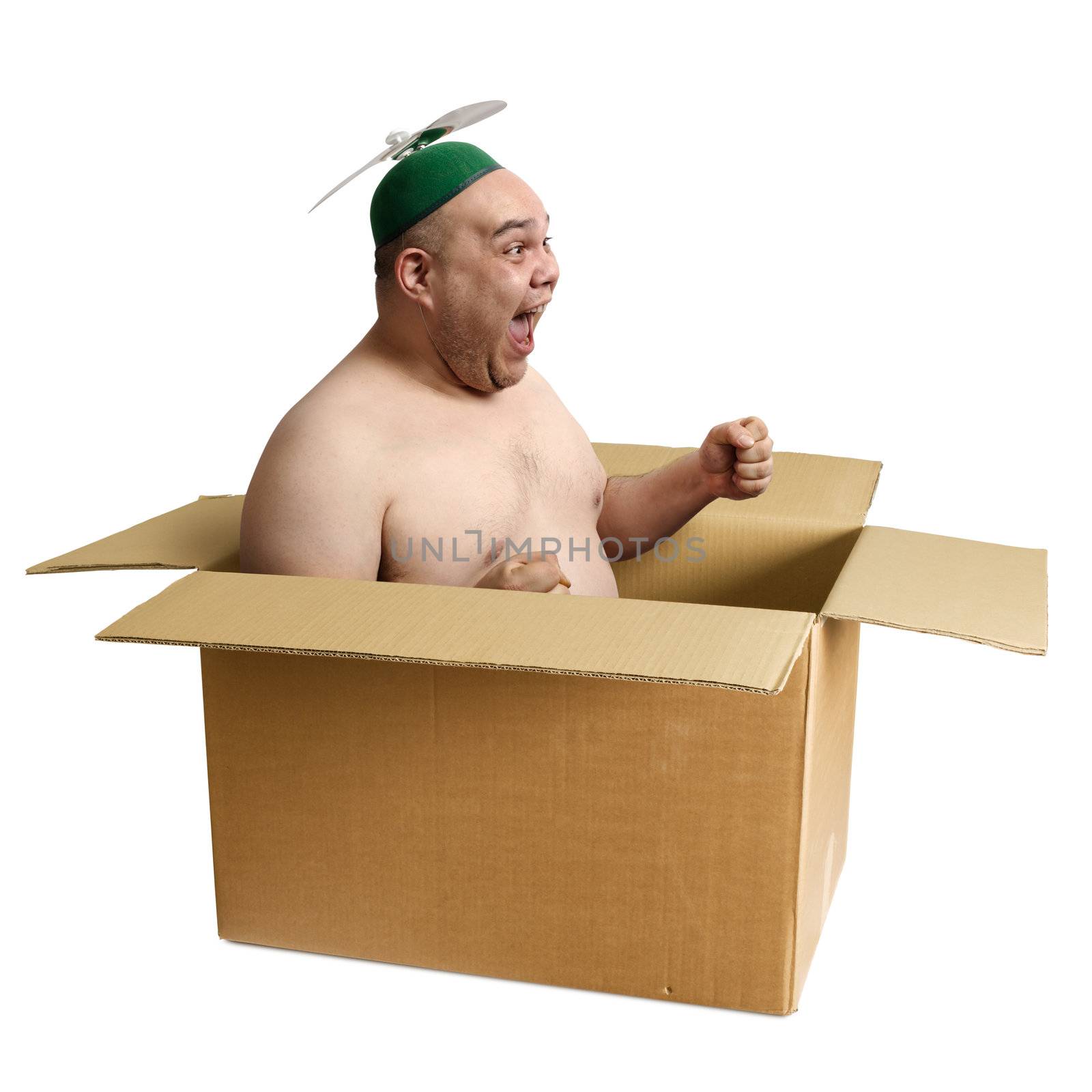 An adult male in his 30's playing airplane in an old cardboard box.