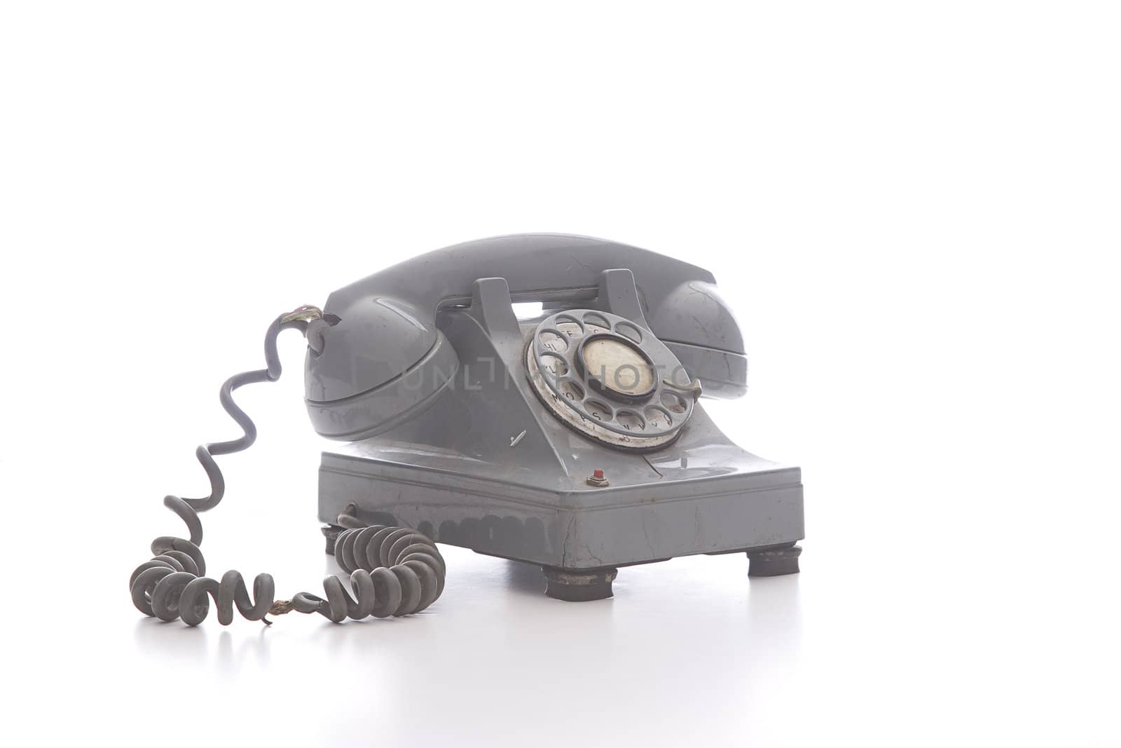 dirty vintage gray rotary phone with crack casing and expose wired