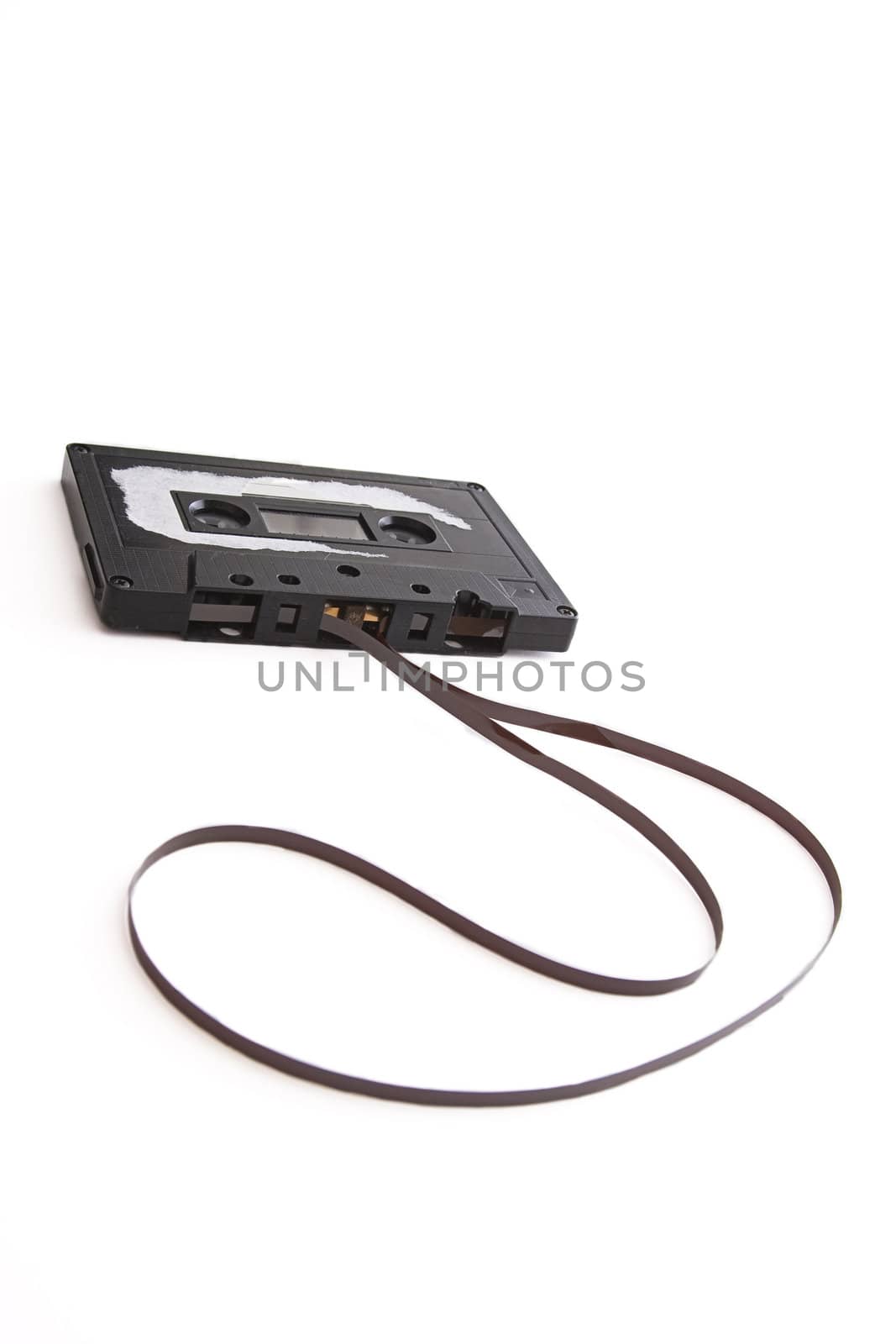 old tape cassette with cover sticker rip apart and part of the tape unrolled