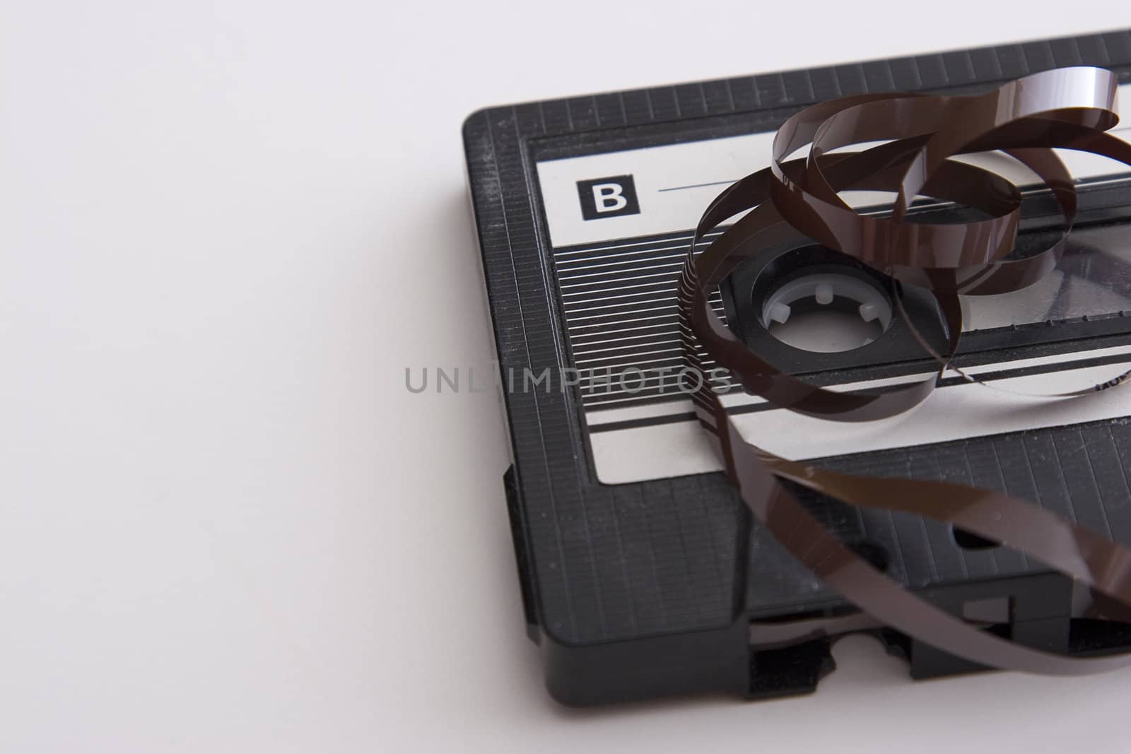 old tape cassette with cover sticker and part of the tape unrolled