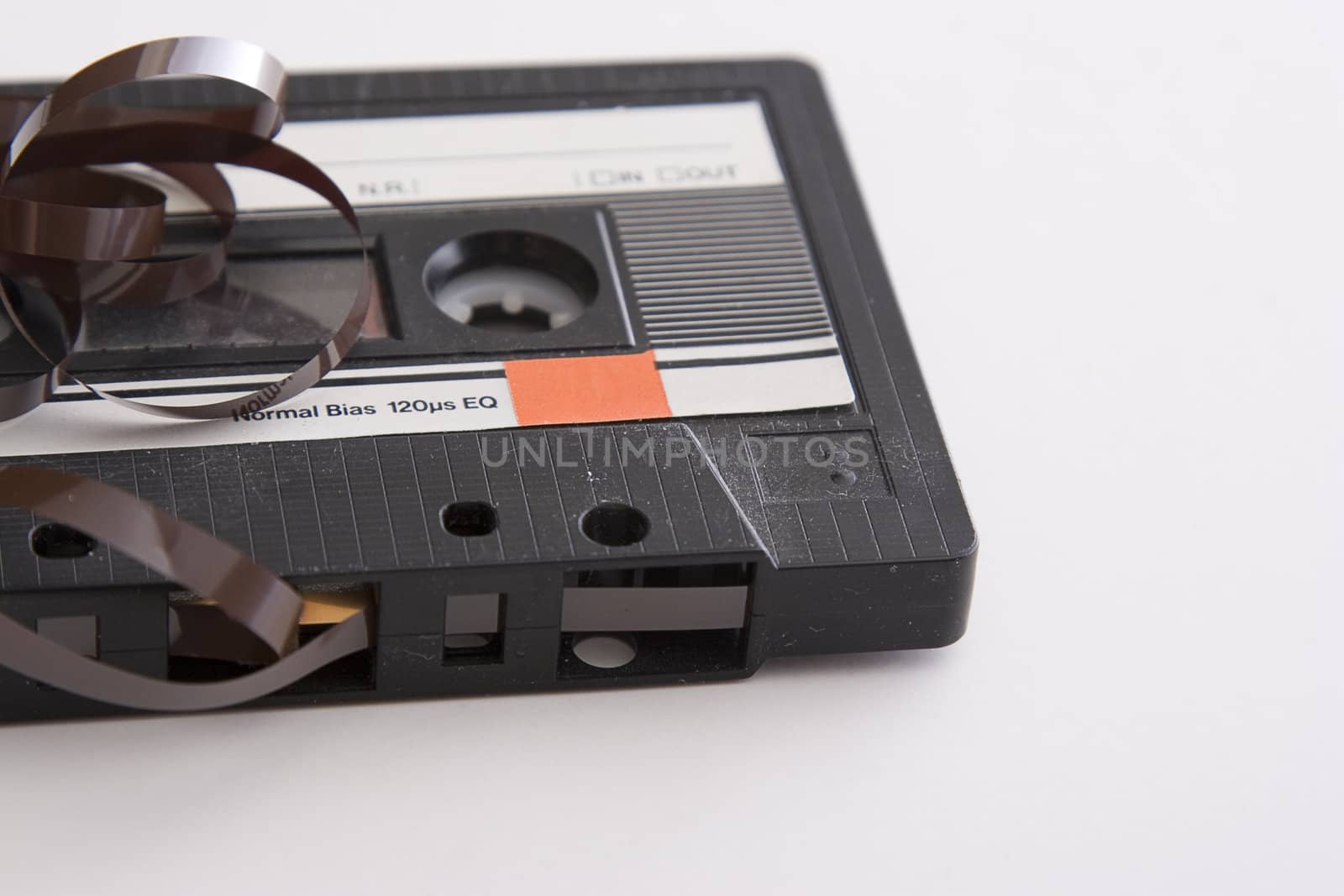 old tape cassette with cover sticker and part of the tape unrolled