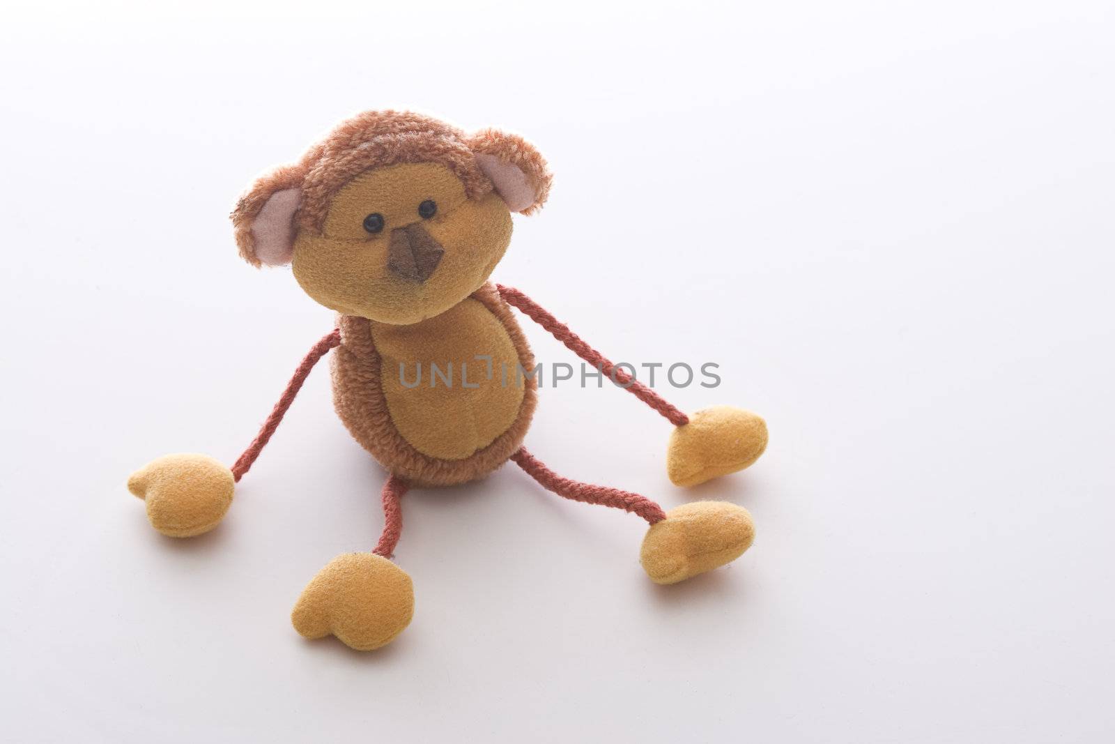 orange monkey toy with strings for arms