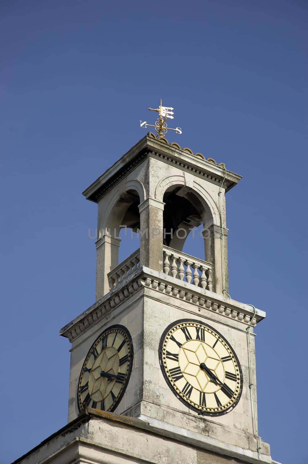 A clock tower with a weather vein on top