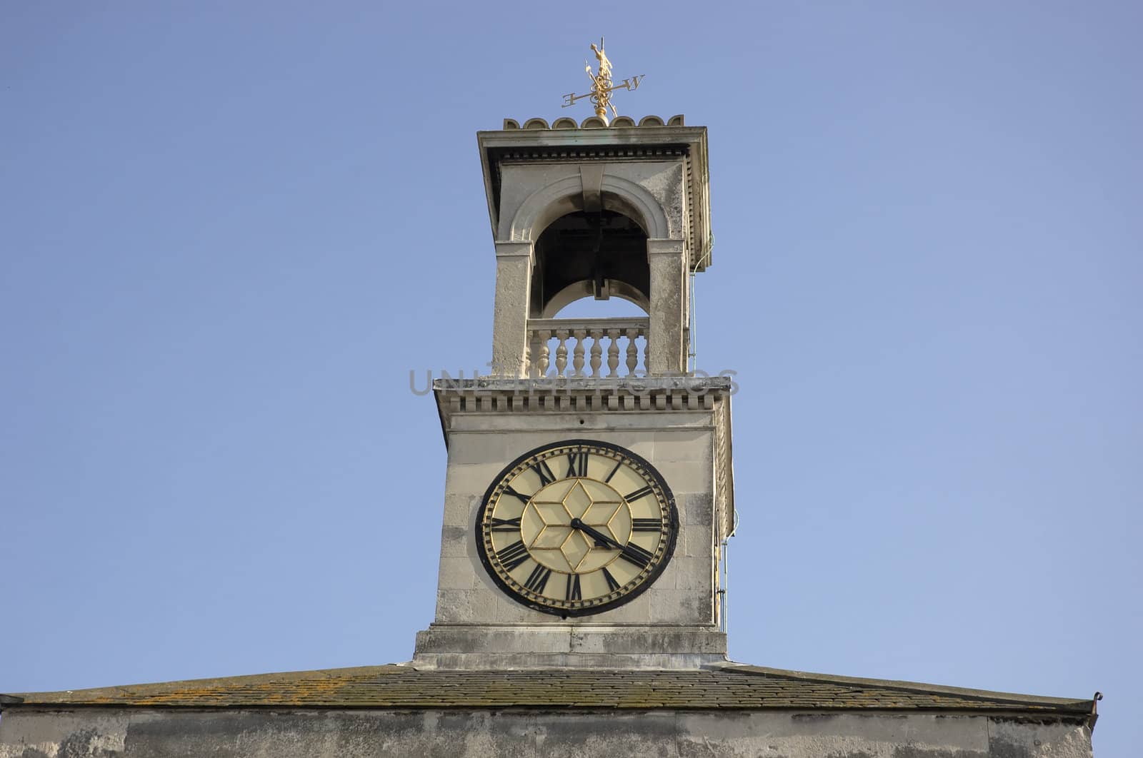 A clock tower with a weather vein on top
