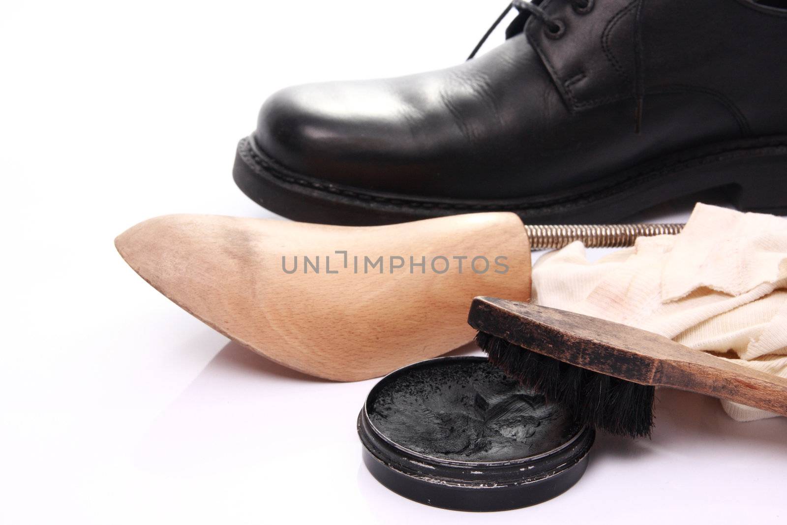 shoe care equipment and formal black shoe on white background