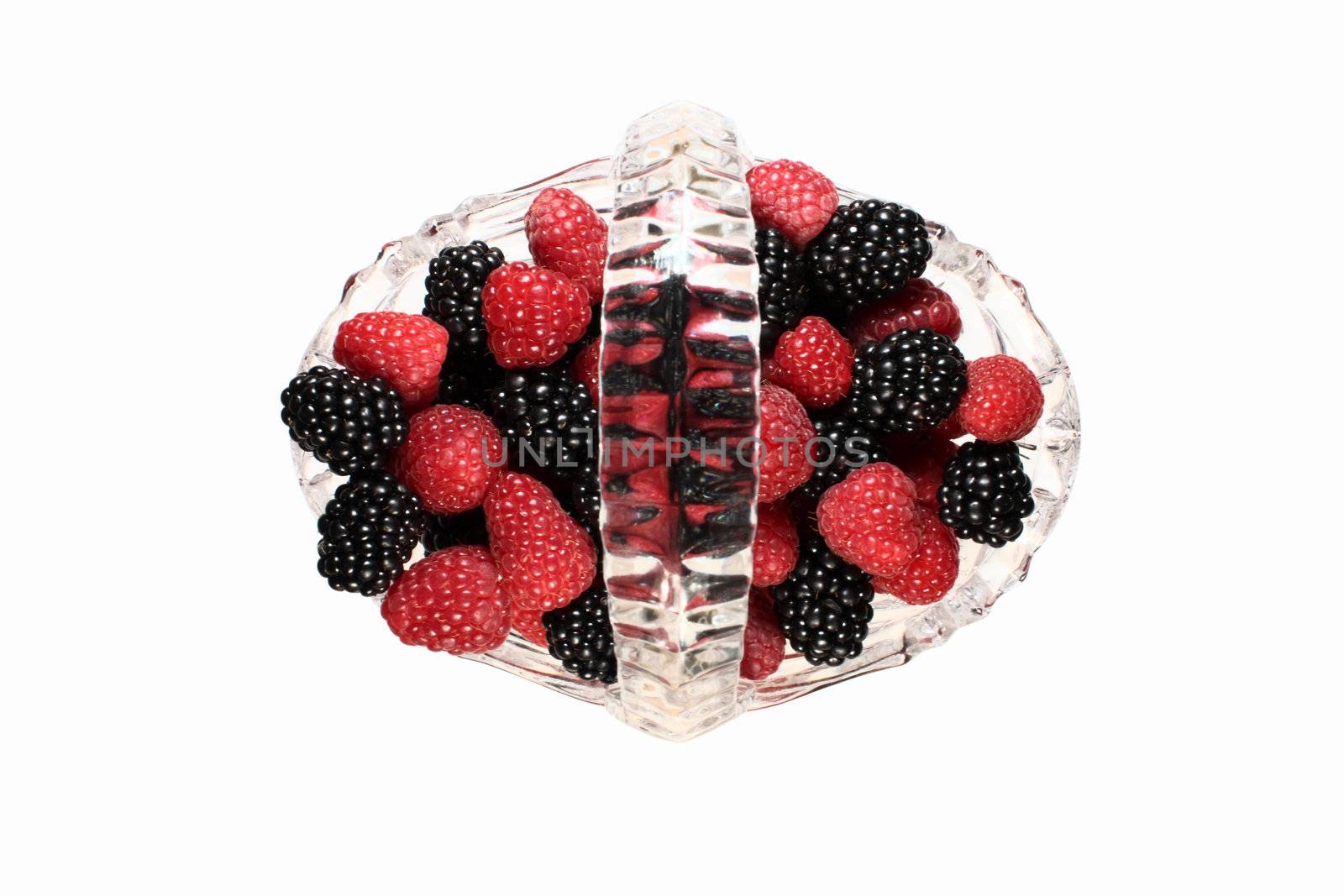 Glass basket full of fresh raspberries and blackberries, top view