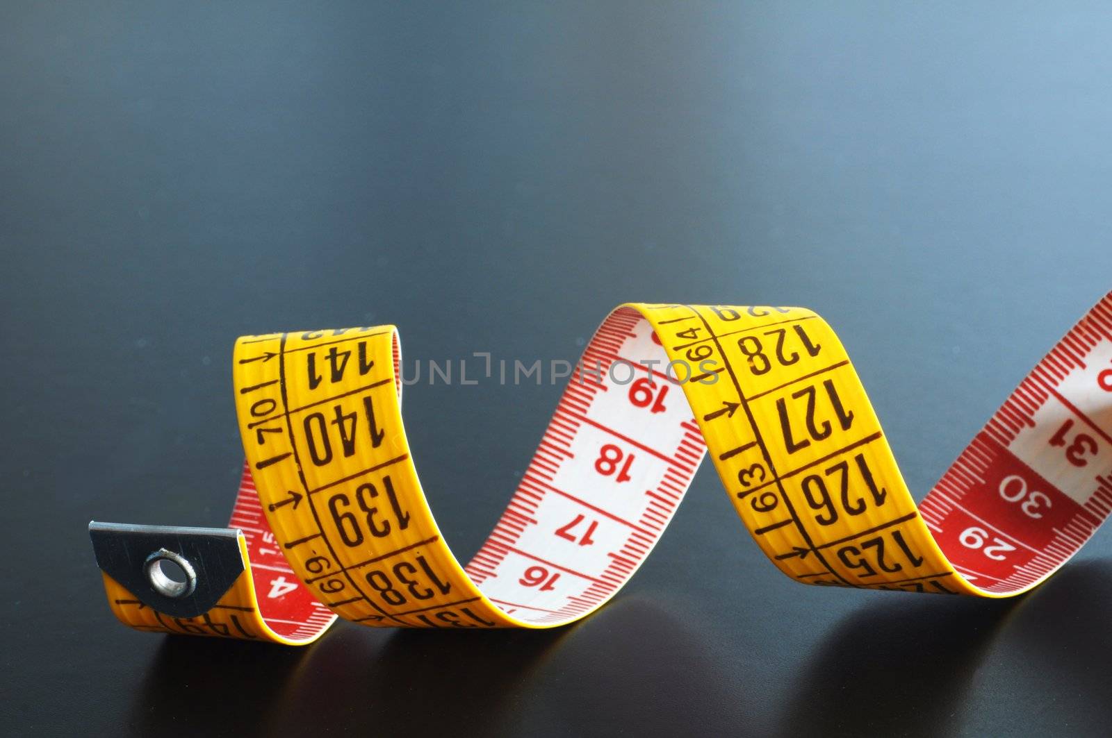 measuring tape on blue or black background showing tailor concept