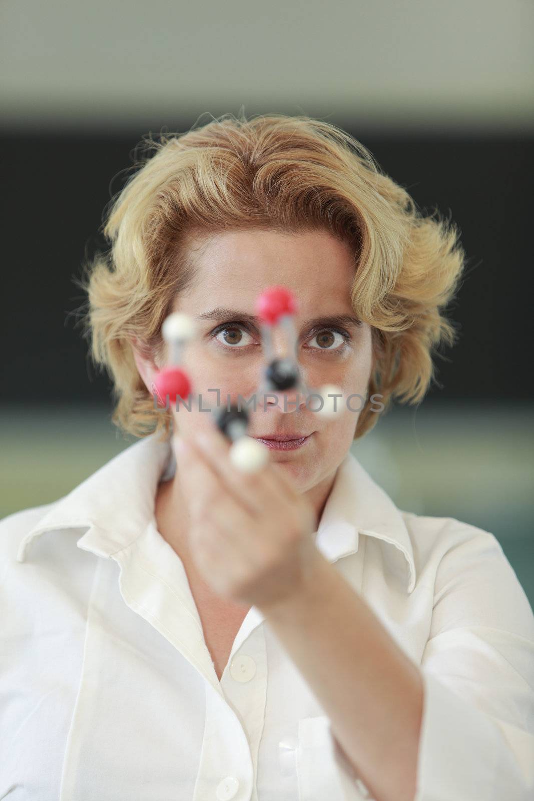Female researcher analyzing a molecular model in a laboratory.