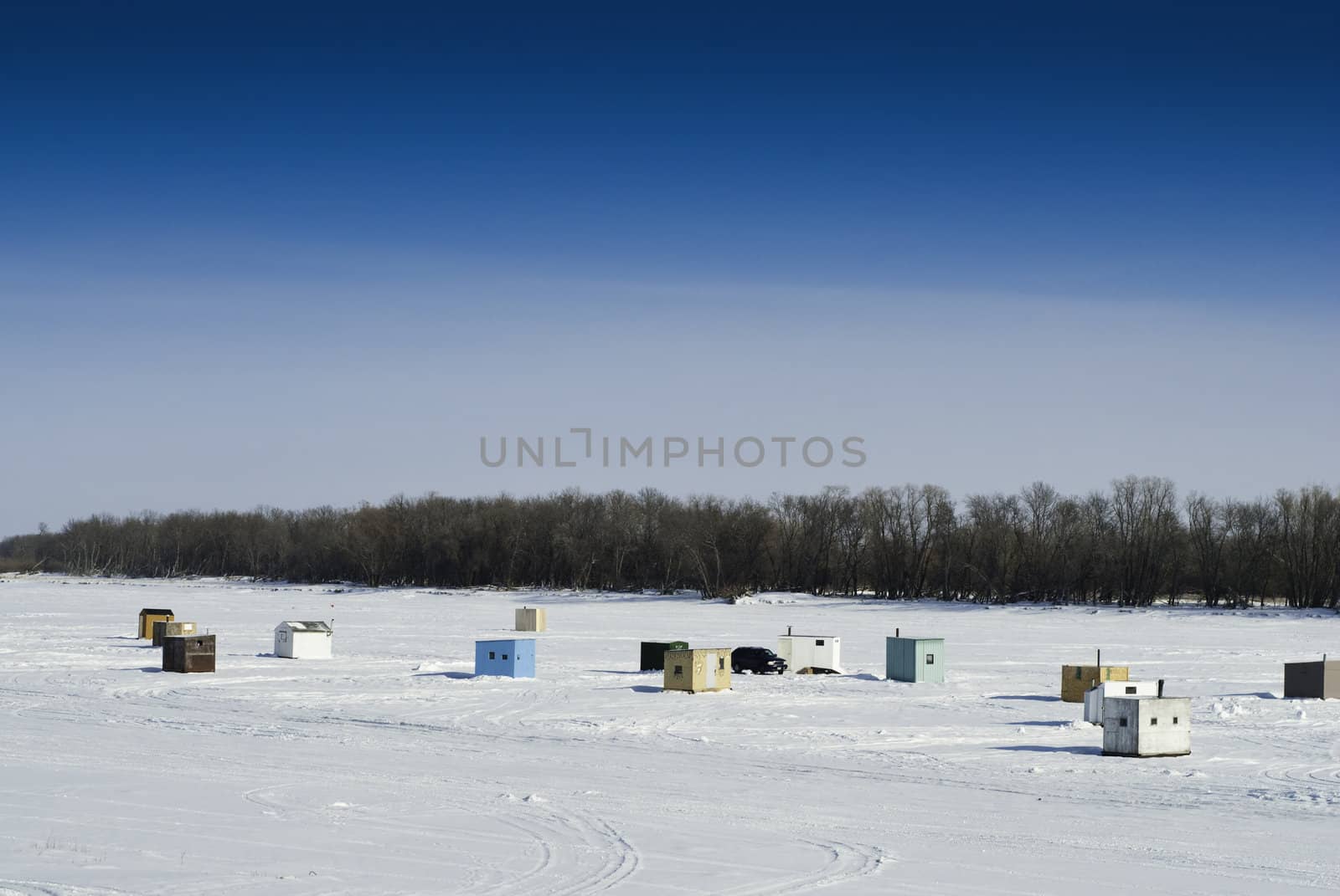 Scattered shacks used for ice fishing situated on the frozen "Red River" in Manitoba.