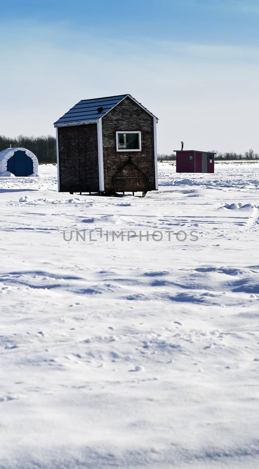 Scattered shacks used for ice fishing situated on the frozen "Red River" in Manitoba.