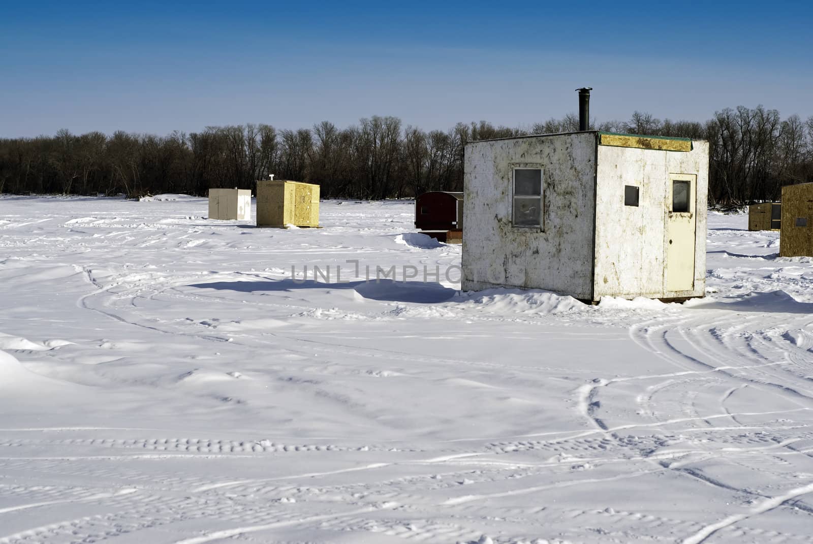 Scattered shacks used for ice fishing situated on the frozen "Red River" in Manitoba.