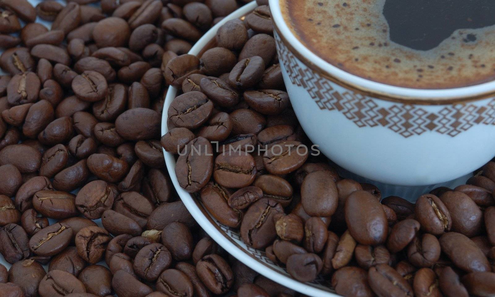 heap of coffee beans and cap of coffee