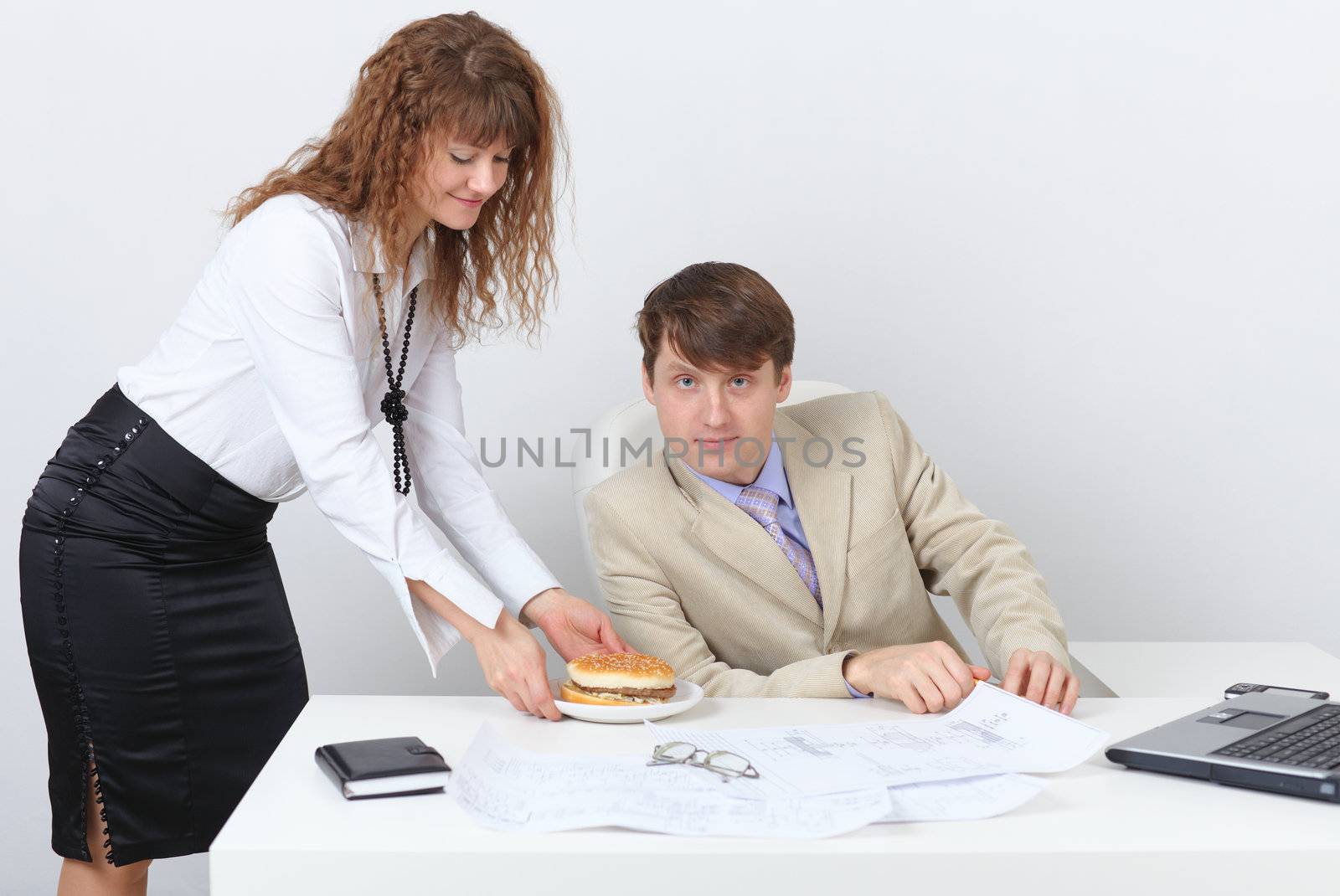 Young people are having dinner at the workplace in a light office