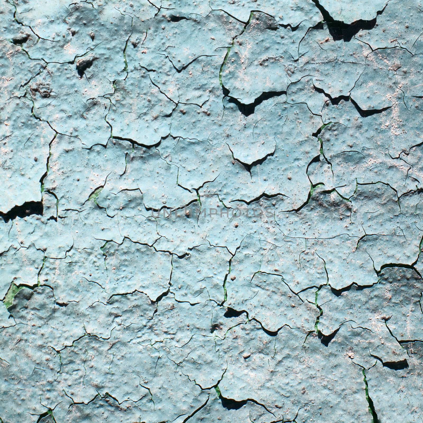 Old blue peeling painted wall with cracks and stains