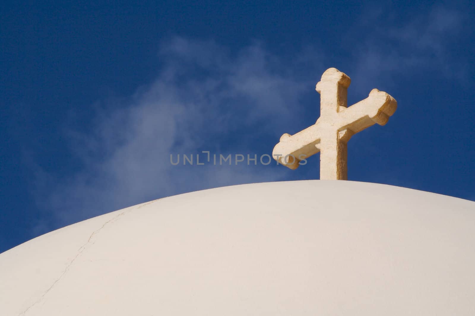 Close-up of dome and cross from Santorini, Greece on a summer day.