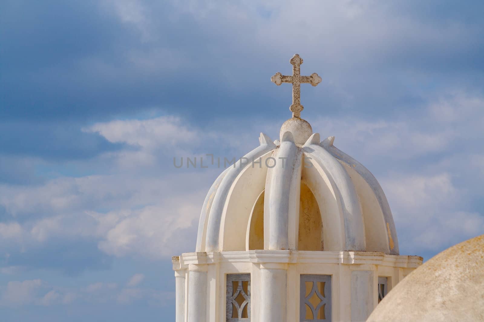 Close-up of dome and cross from Santorini, Greece on a summer day.