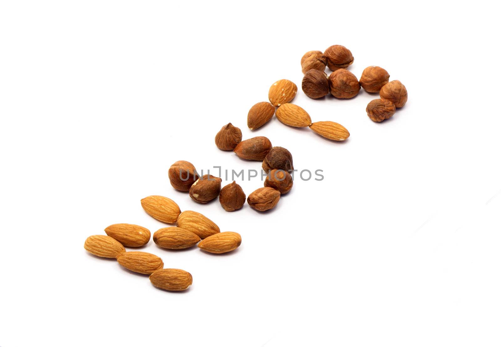 Word NUTS made from cashew and hazelnut on white background