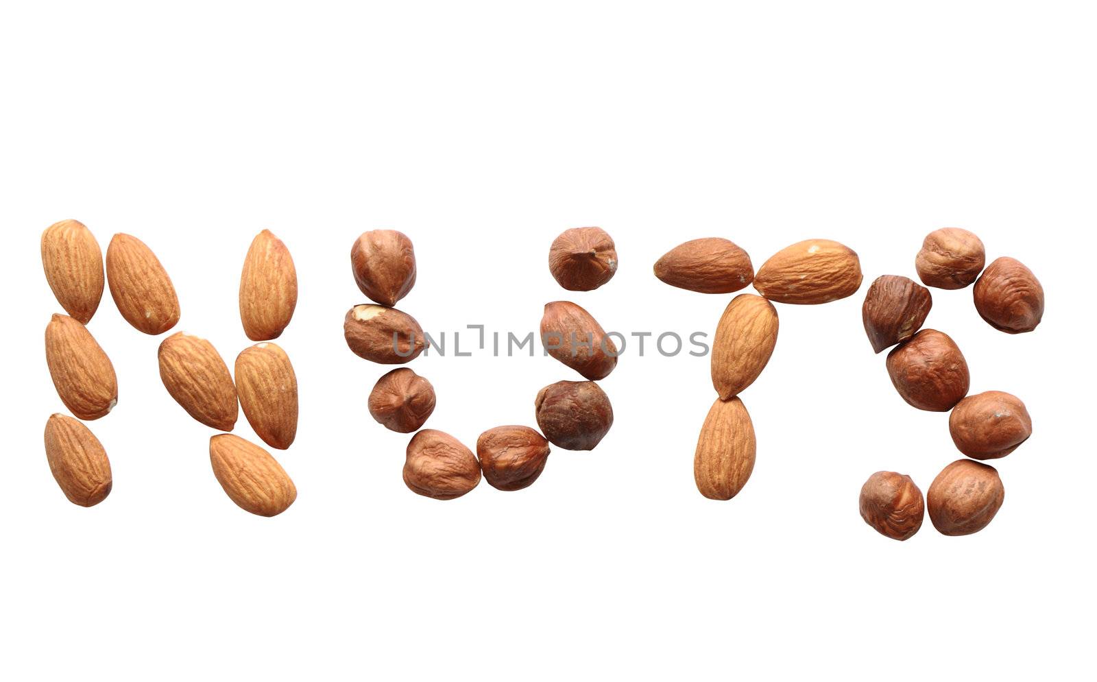 Word NUTS made from cashew and hazelnut on white background. Isolated with clipping path