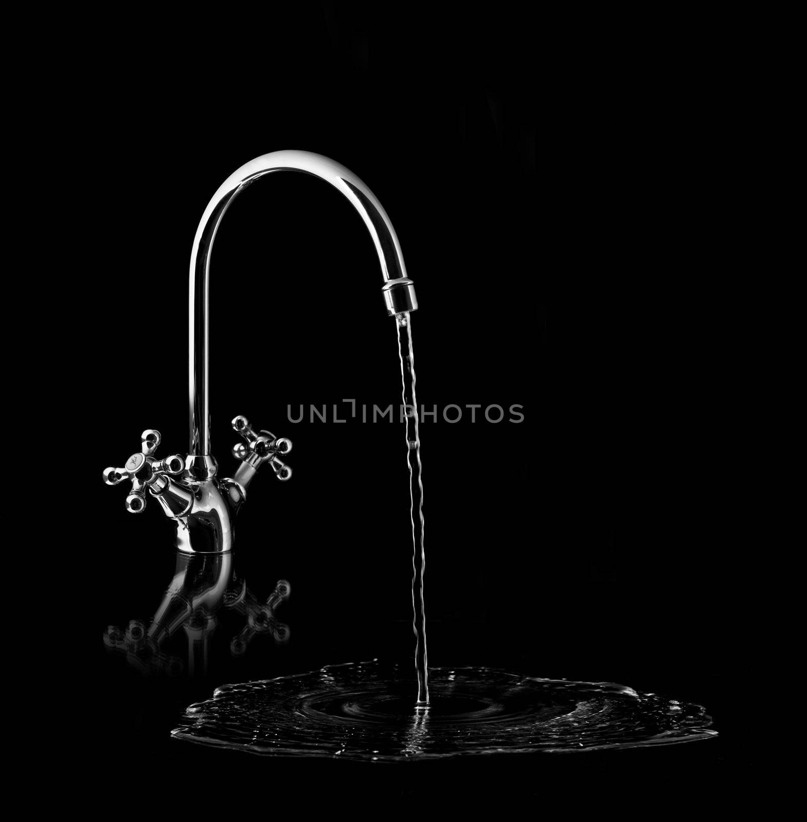 Water tap on black background