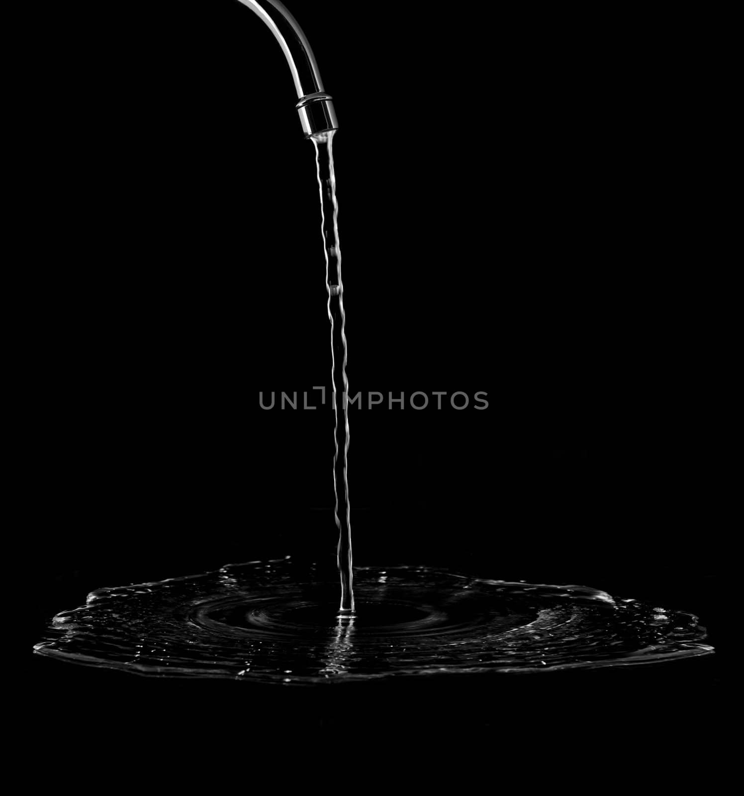 Tap with splashing water on black background
