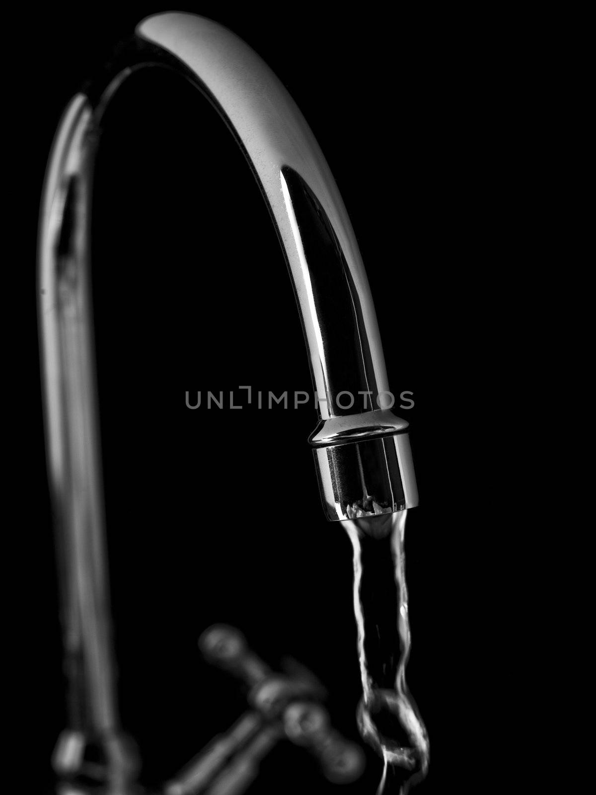 Tap with water on black background