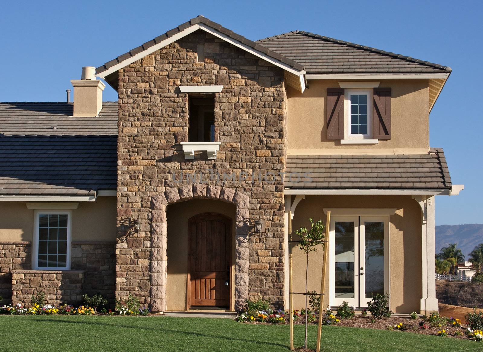 A newly constructed, modern american home with fresh landscaping.