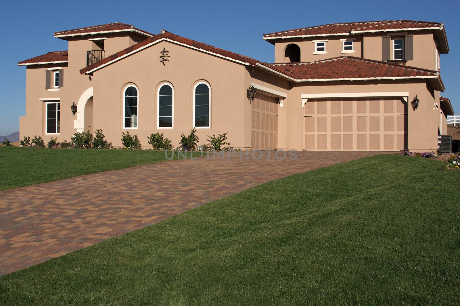 A newly constructed, modern american home with fresh landscaping.