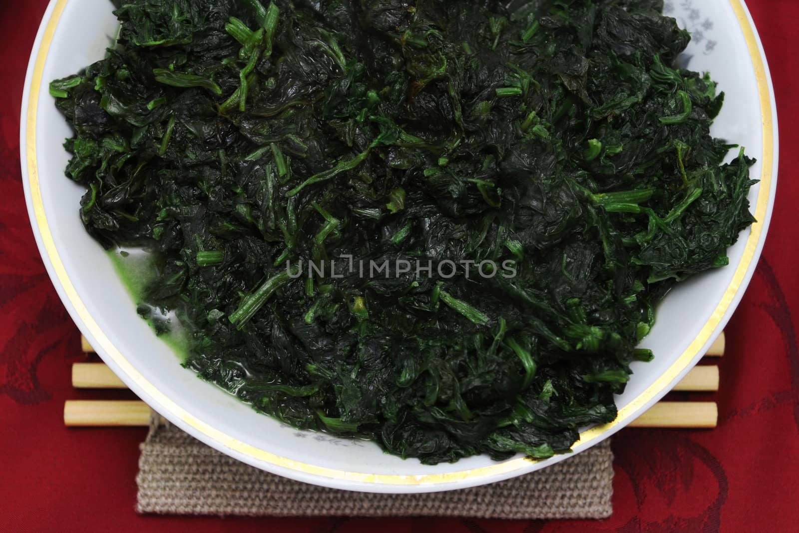 Green spinach dish on the red background