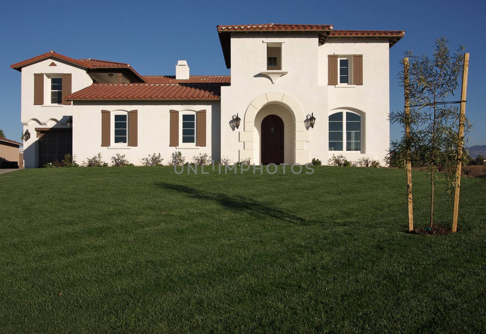 A newly constructed, modern american home with fresh landscaping.