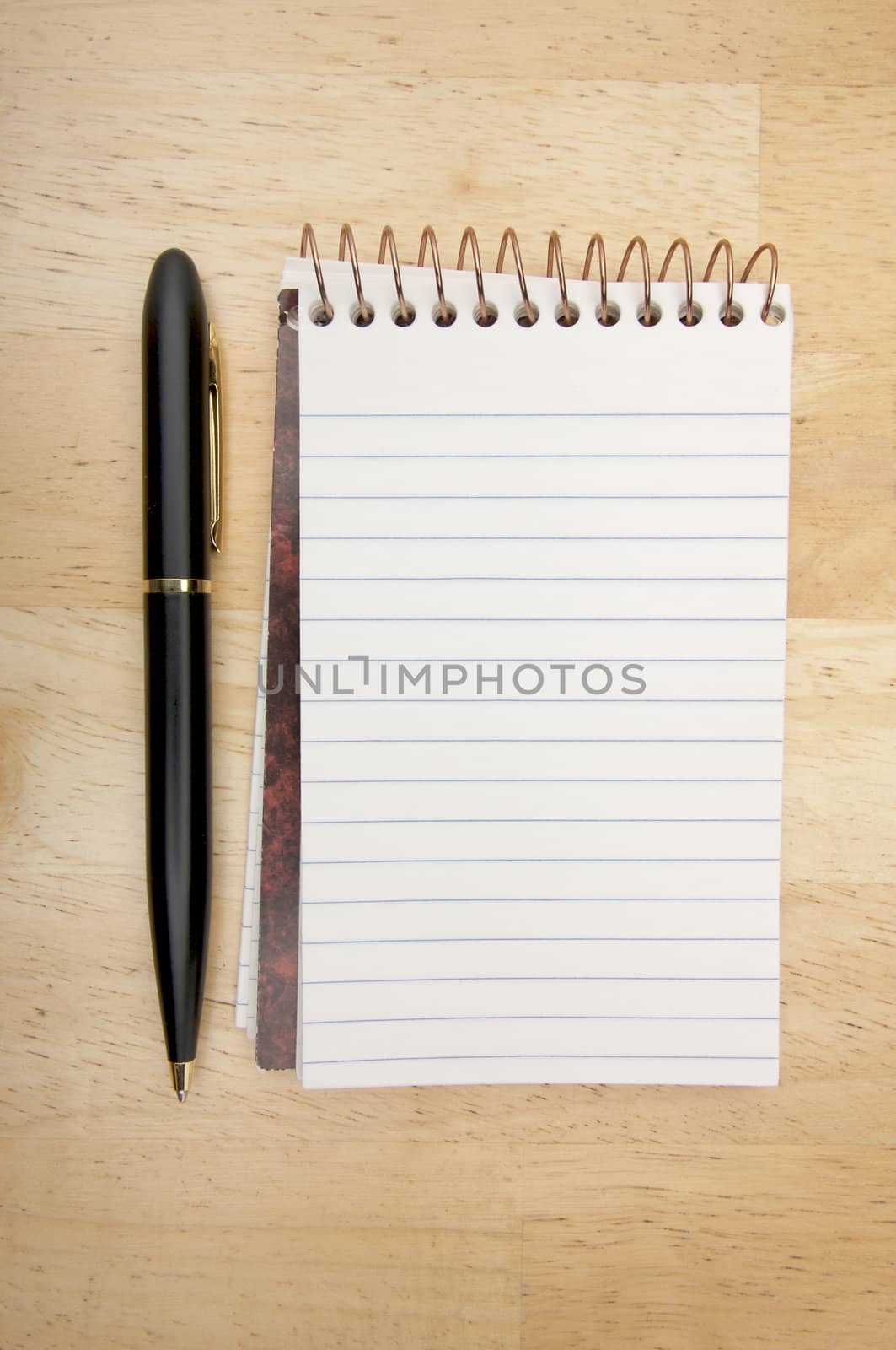 Note Pad and Pen on Wood Background