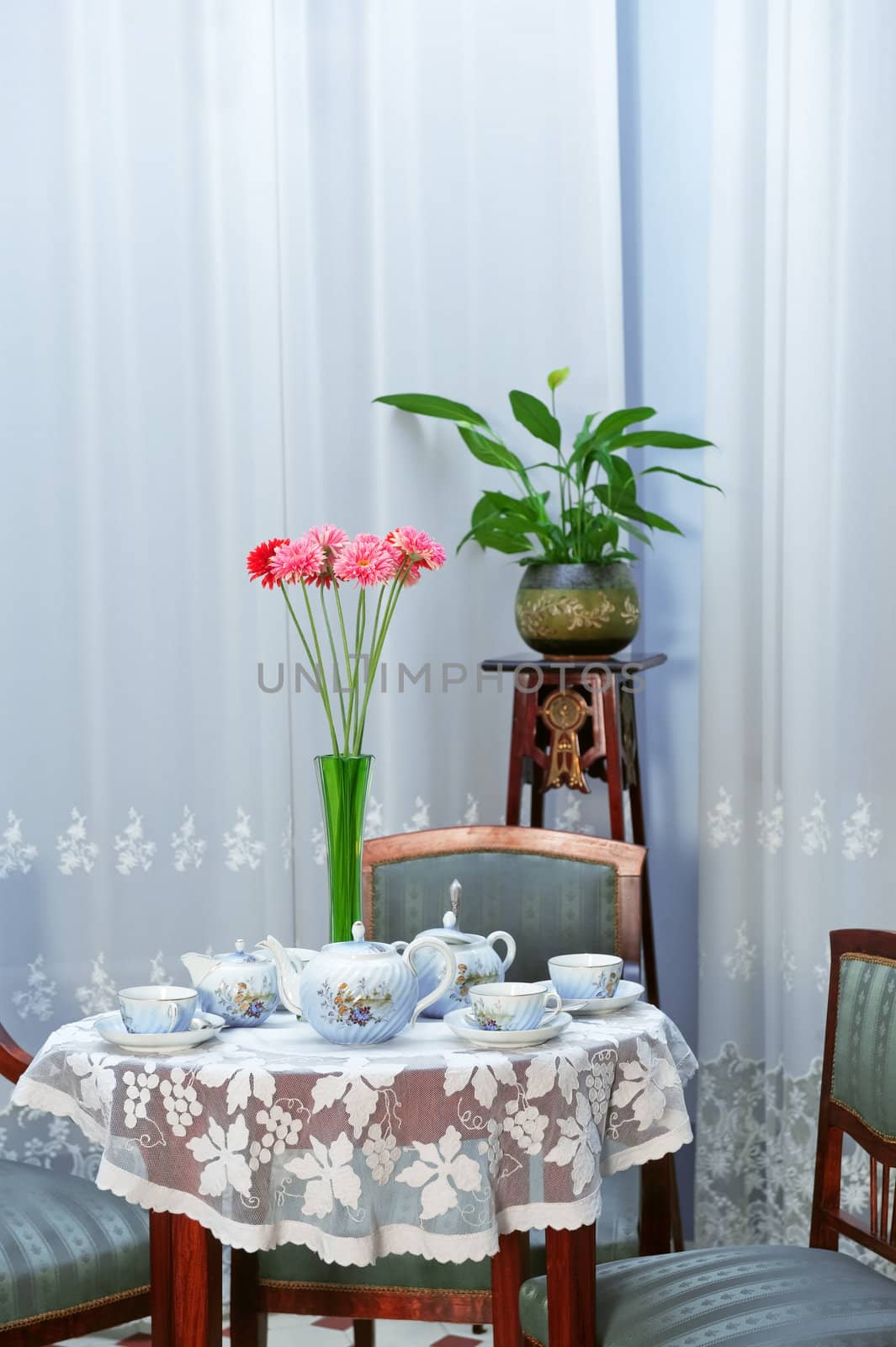 Table setting with tea service and flowers in vase