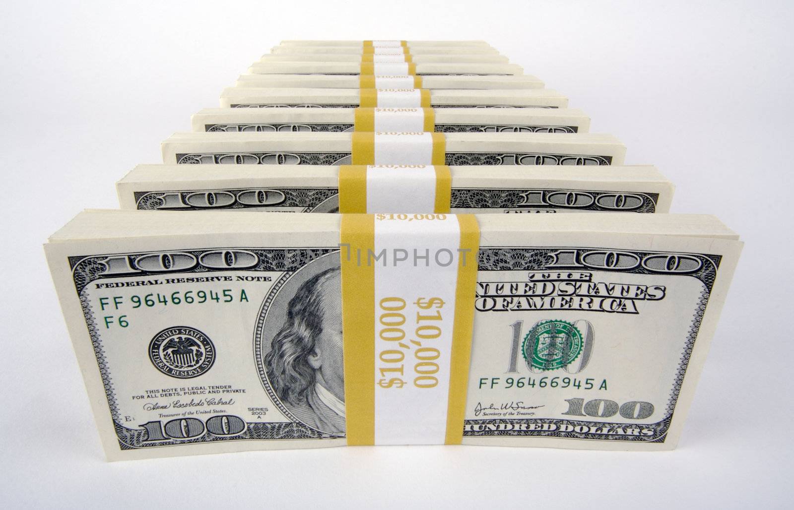 Stacks of Hundred Dollar Bills on a white background.