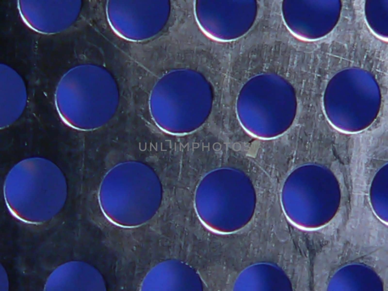 macro detail of kitchen strainer with blue background