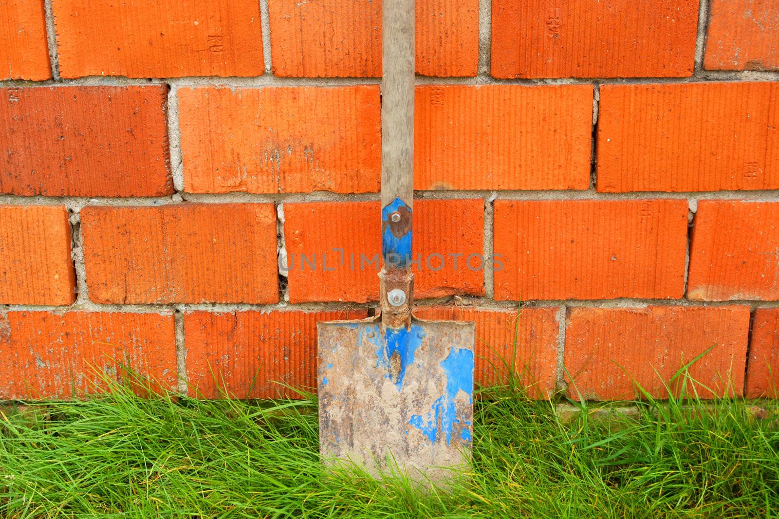Spade on the red brick wall background